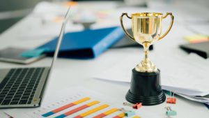 Trophy with Laptop and Charts