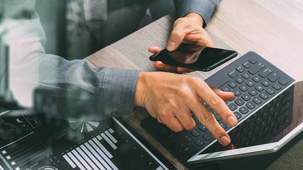 Businessman using phone and tablet for digital banking